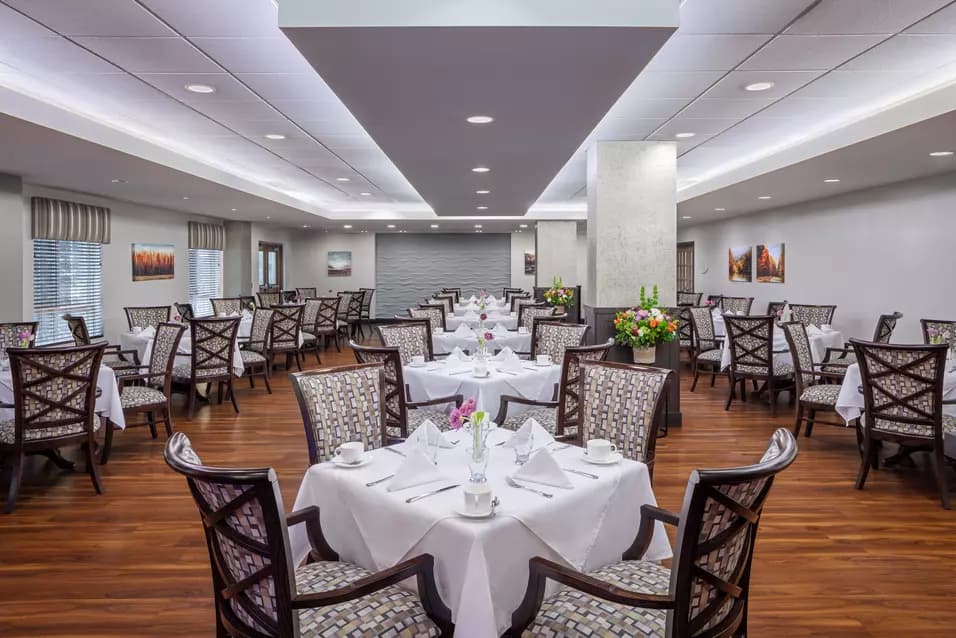 elegant dining with white linens at chartwell fountains of mission retirement residence