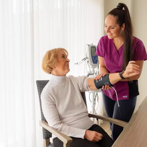 Chartwell staff is taking a blood pressure of a resident / Le personnel de Chartwell prend la tension artérielle d'une résidente