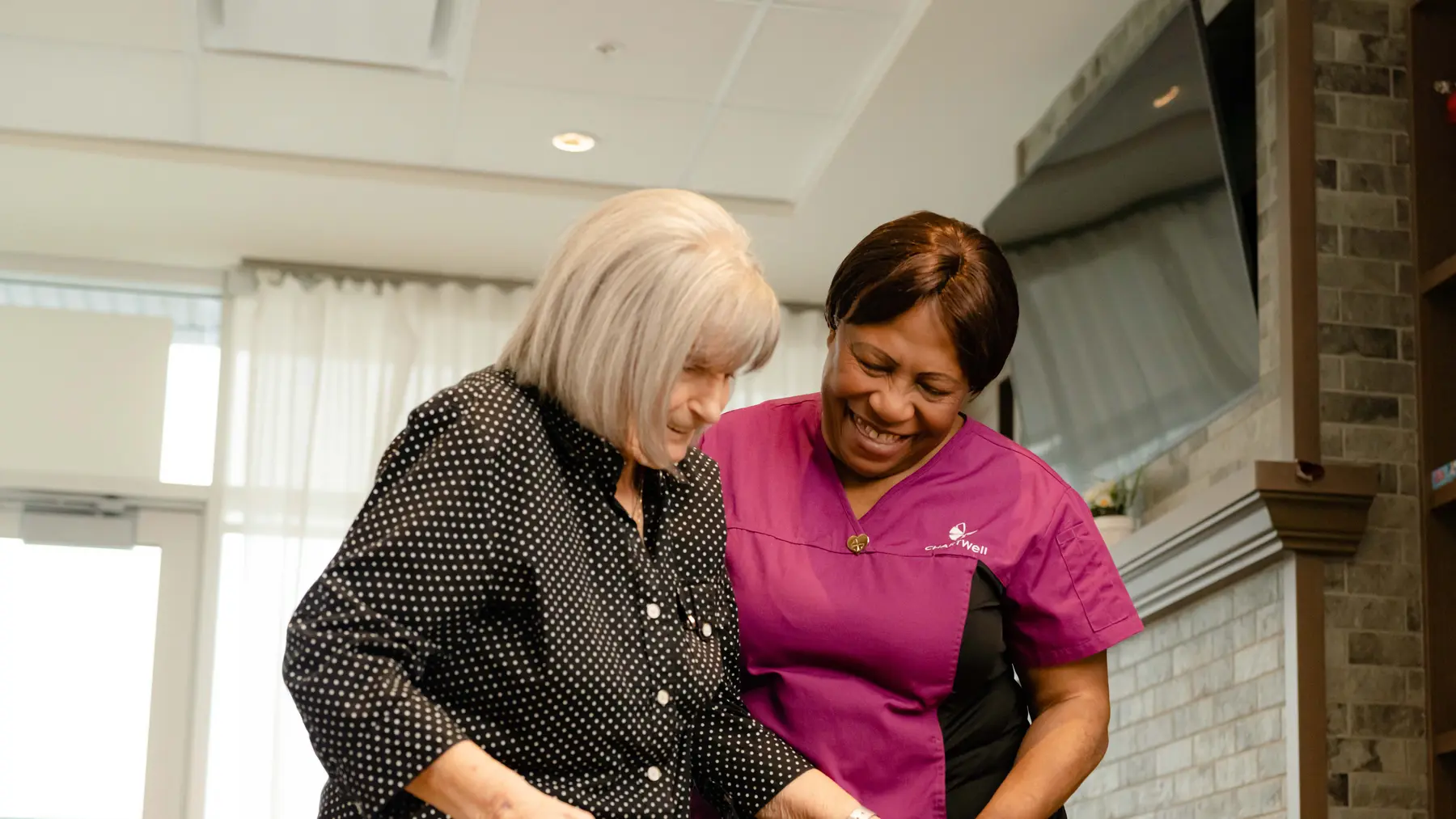 Chartwell care staff helping the senior resident with her walker