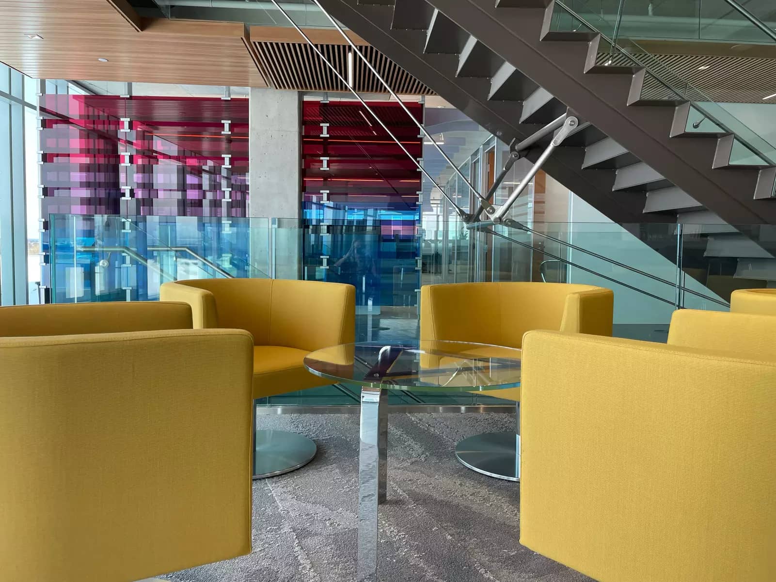 Four yellow chairs surrounding a glass table at Chartwell Retirement Residence's head office. Quatre chaises jaunes entourant une table en verre au siège social de Chartwell residence pour retraites