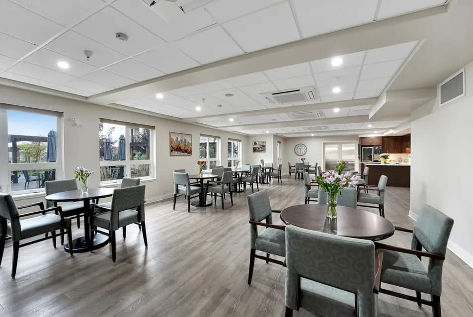 Lounge with tables and chairs at Chartwell Ridgepointe / Salon avec tables et chaises à Chartwell Ridgepointe