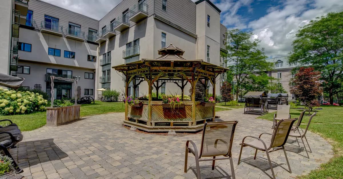 Cour extérieure avec belvédères, chaises et balançoires Chartwell Jardins de la Gare résidence pour retraités