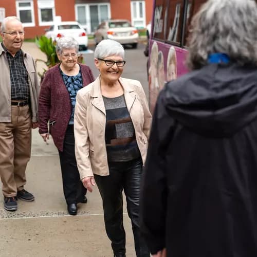Senior residents at Chartwell residence are boarding a shuttle bus and getting greeted by the Chartwell staff / Les résidents âgés de la résidence Chartwell montent à bord d'une navette et sont accueillis par le personnel de Chartwell